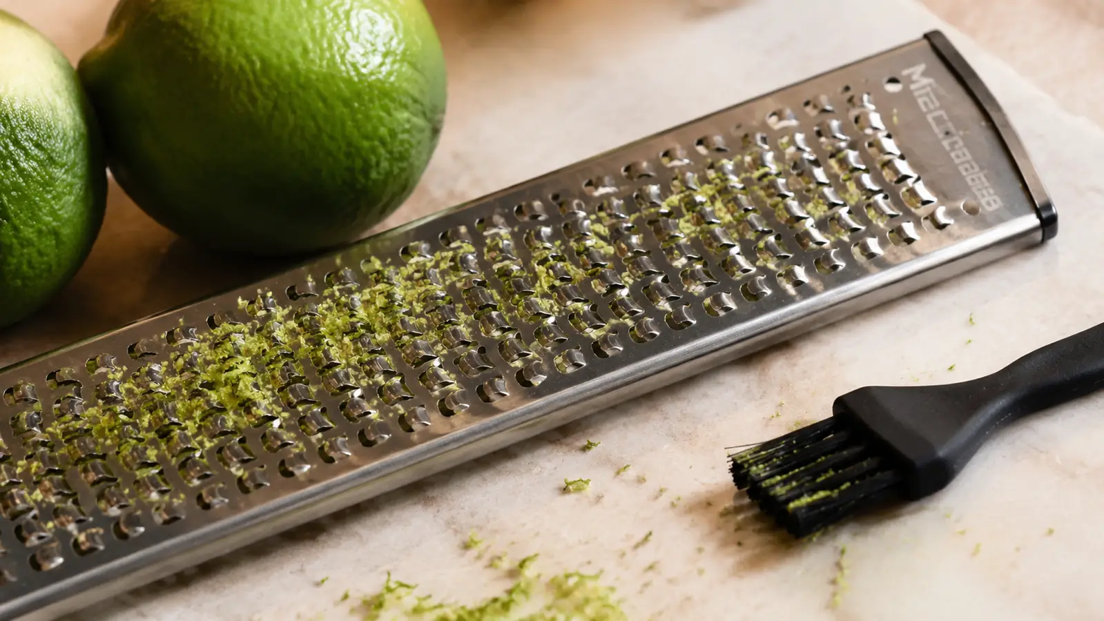 Close-up of stuck lime zest caught in the fine teeth of the Microplane blade before cleaning